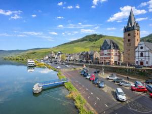 a town next to a river with cars parked at Quelle in Bernkastel-Kues