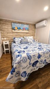 a bedroom with a bed with a blue and white comforter at Happier in the Keys Waterfront Tiny Home in Key Largo +37 photos