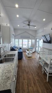 a kitchen and living room with a couch and a table at Happier in the Keys Waterfront Tiny Home in Key Largo