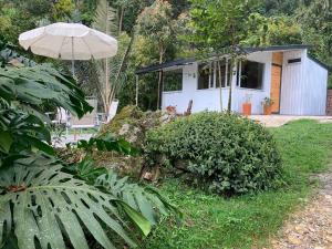 a small white house with an umbrella in a yard at Cabaña Corolaine in San Francisco