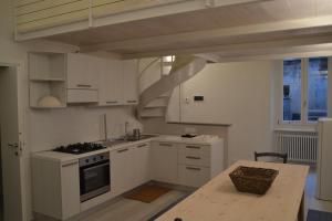 フィナーレ・リーグレにあるTerra Azzurraの白いキャビネットとテーブル、階段付きのキッチン