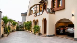 a building with cars parked in a driveway at DeBoss Hotel in Ikeja