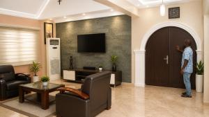 a man standing at the door of a living room at DeBoss Hotel in Ikeja