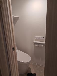a small bathroom with a toilet and a light at StadtLeben東北ゲートウエイ2新築広々仙台駅徒歩5分 in Sendai +6 photos