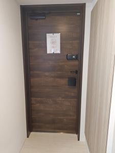 a wooden door in a room with a sign on it at StadtLeben東北ゲートウエイ2新築広々仙台駅徒歩5分 in Sendai