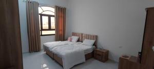 a small bedroom with a bed with a window at رزات كاسا - للعائلات فقط in Gharnūt +21 photos