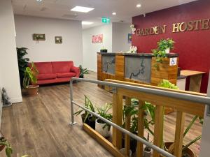 a waiting room at a chicken hospital with a red couch at Garden Hostel in Auckland