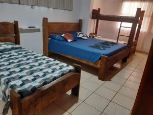 a bedroom with two beds with blue sheets at Recanto Praia Peruibe in Peruíbe +27 photos