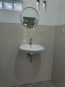 a white sink in a bathroom with a mirror at Tetebatu Backpackers Base in Selong