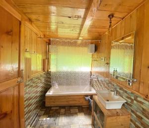 a bathroom with a tub and a sink at Himalayan Abode Tree House in Sainj