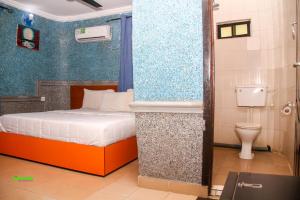 a small bedroom with a bed and a toilet at DeBoss Hotel in Ikeja +21 photos