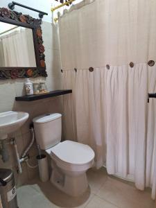 a bathroom with a white toilet and a sink at finca nalu in Jardin +14 photos