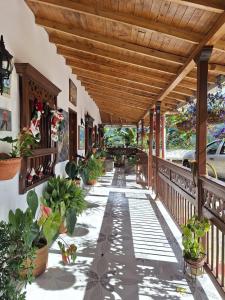a porch with potted plants and a wooden roof at finca nalu in Jardin