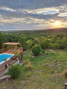a house with a swimming pool on top of a hill at Cabañas Damel in Villa Giardino