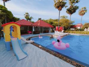 a pool with a slide and inflatable flamingos in the water at Baan Golden Resort & Residences in Sam Roi Yot