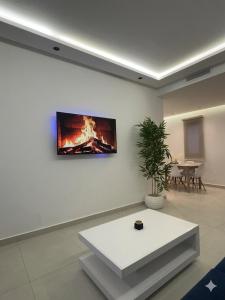 a living room with a tv on a wall at Cozy Flat Sea & Hills View in Marina Smir