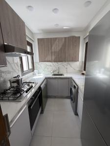 a kitchen with white counters and a stove top oven at Cozy Flat Sea & Hills View in Marina Smir