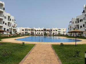 a large pool in front of some apartment buildings at Cozy Flat Sea & Hills View in Marina Smir