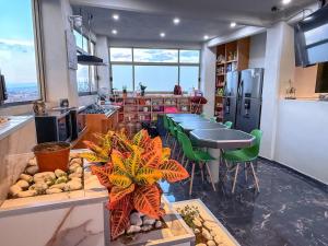 a kitchen with tables and green chairs in a room at Habitación individual con baño privado a 2 min de Ciudad Universitaria - UNAM - Institutos de Investigación in Mexico City