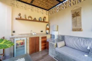 a living room with a couch and a kitchen at MELO Gili Air in Gili Islands