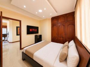 ein Schlafzimmer mit einem großen Bett und einem Spiegel in der Unterkunft Exclusive Executive & Couple Suite con Piscina in Machala