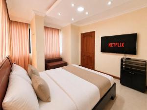 ein Hotelzimmer mit Bett und Fernseher in der Unterkunft Exclusive Executive & Couple Suite con Piscina in Machala