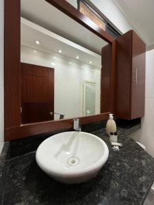 ein Badezimmer mit Waschbecken und großem Spiegel in der Unterkunft Exclusive Executive & Couple Suite con Piscina in Machala