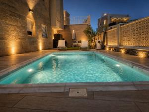 a swimming pool with lights on the side of a building at בית נופש - הדקל והים אילת in Eilat
