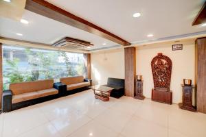 a living room with two couches and a large window at Hotel O Ganpati in Bhopal +26 photos