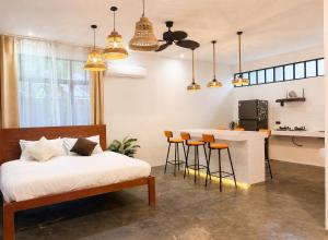 a bedroom with a bed and a bar with stools at Hideout Siargao in General Luna