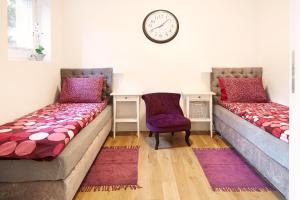 ワルシャワにあるLovely LUX Garden Flat near Royal Parkのベッド2台、壁掛け時計付きの客室です。