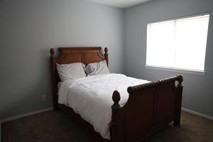a bedroom with a large bed with white sheets and a window at Bluebonnet Retreat in Flower Mound