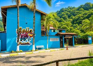 a blue building with graffiti on it on a street at Beija Flor Pousada in Ubatuba +16 photos