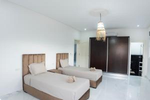 a bedroom with two beds and a large window at Villa Raha in Selouane