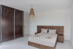a bedroom with a large bed and a glass shower at Villa Raha in Selouane