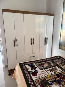 a bedroom with white cabinets and a table with a rug at Casa Cielo y Noche in Ahuachapán +22 photos