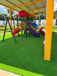 a playground with colorful slides and swings on grass at Casa Cielo y Noche in Ahuachapán