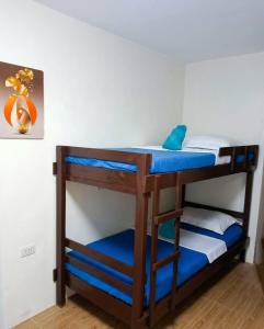 a bunk bed with blue sheets and a blue pillow at 3 J'S Homestay in Carles