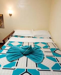 a bed with a blue and white tiled floor at 3 J'S Homestay in Carles