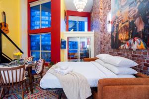 a bedroom with a bed and a table and windows at Casa DT Vancouver - Mexican Theme in Vancouver