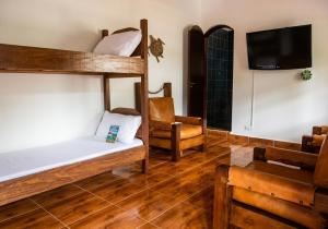 a room with two bunk beds and a chair at Cantinho no litoral a 100mts da praia in São Sebastião