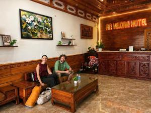 two people sitting in a waiting room at a restaurant at An Velora Boutique Hotel in Lai Nghê (2) +35 photos