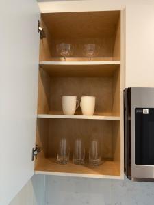 a cupboard with bowls and wine glasses in it at Downtown Escape in Surrey