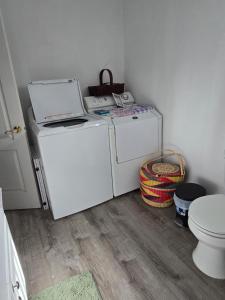 a small bathroom with a washing machine and a toilet at Lillian's Cozy Corner in Palmer +2 photos