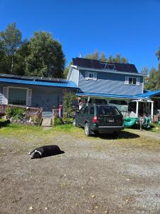a dog laying on the ground in front of a house at Lillian's Cozy Corner in Palmer