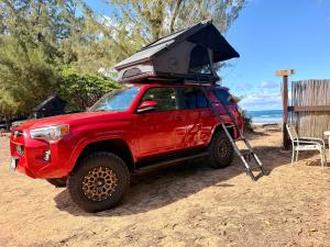 a red truck with an umbrella on top of it at GetUp&Go! Rooftop Camper fully equipped SUV in Anahola