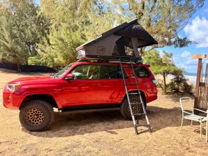 a red jeep with a tent on top of it at GetUp&Go! Rooftop Camper fully equipped SUV in Anahola +2 photos
