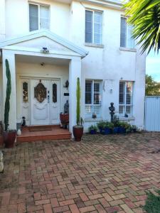 a white house with a brick driveway at 1 bed room dog friendly accommodation in Tarneit