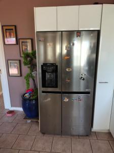 a stainless steel refrigerator with stickers on it at 1 bed room dog friendly accommodation in Tarneit