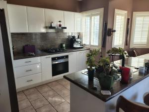 a kitchen with white cabinets and a counter top at 1 bed room dog friendly accommodation in Tarneit